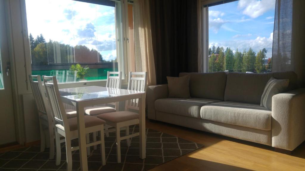 坦佩雷Pähkinäpuisto Apartments的客厅配有沙发和桌椅