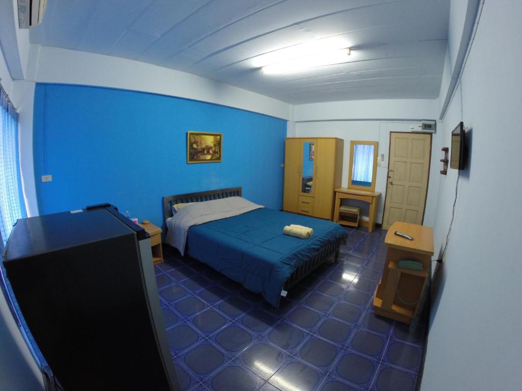 三帕兰地球庄园5号公寓的一间蓝色卧室,配有一张床和电视