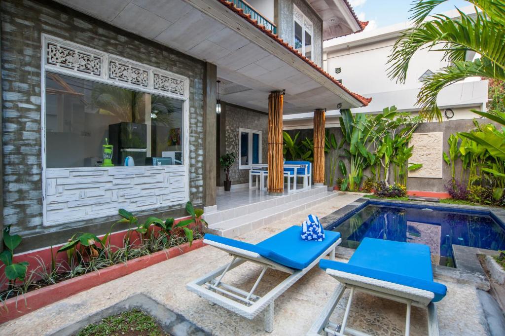 塞米亚克塞米亚克瑞吉别墅的一个带2把蓝色躺椅的庭院和一个游泳池