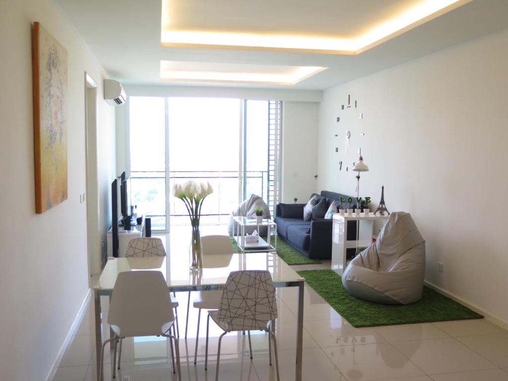 马六甲舒适马六甲住宅公寓的客厅配有桌子和一些椅子