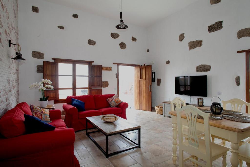 马赫Caserío Leandro III的客厅配有红色的沙发和桌子