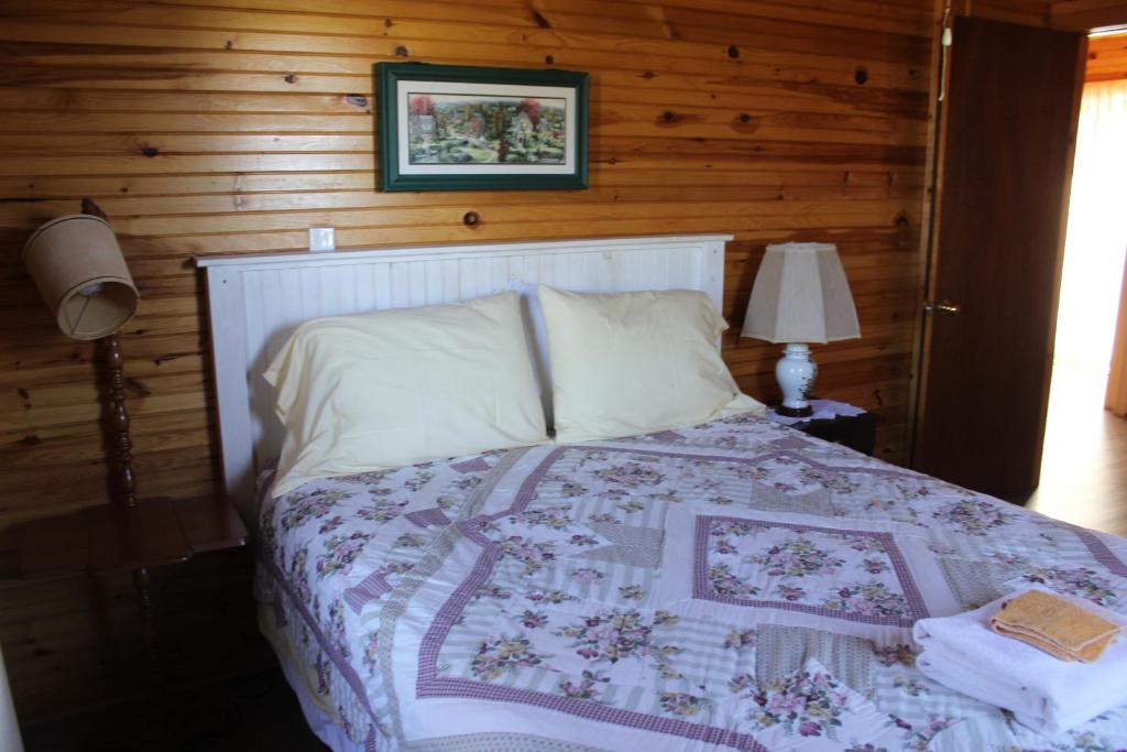 北拉斯蒂科Chalets Grand Pre Cottages的一间卧室配有床,床上装有被子