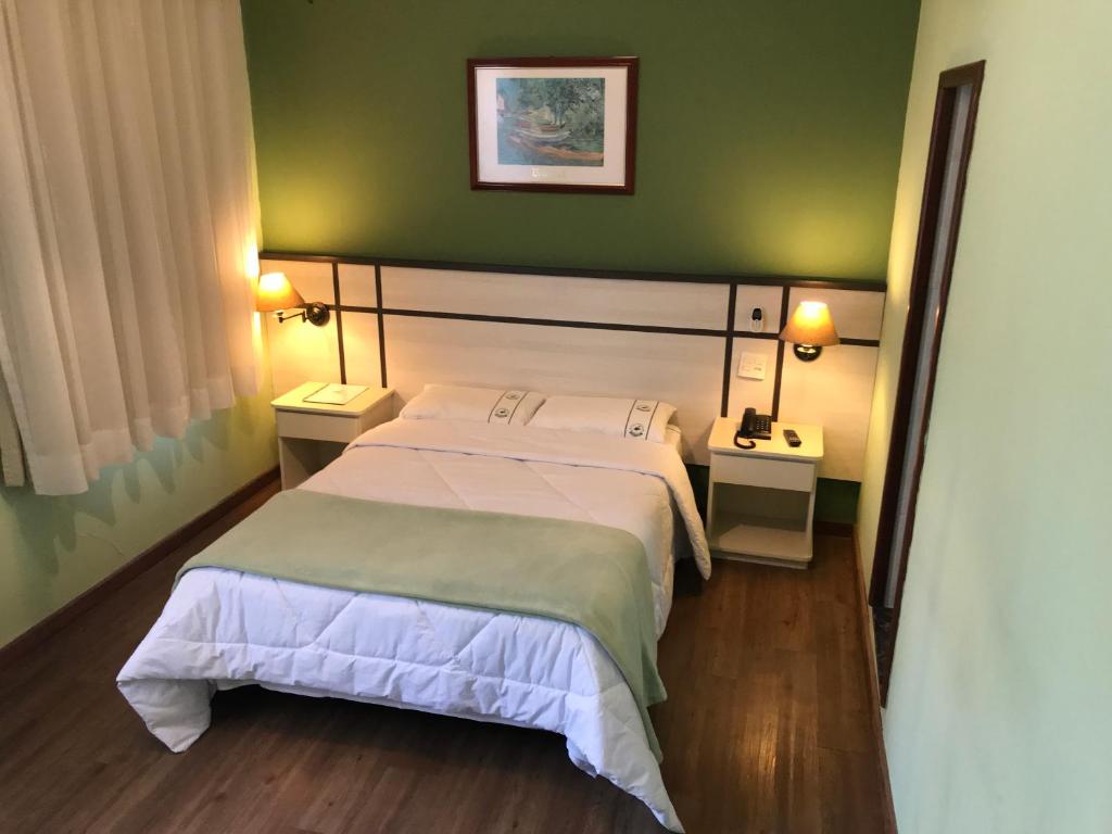 圣保罗Residencial Pantanal Vila Mariana的一间卧室设有一张床和绿色的墙壁