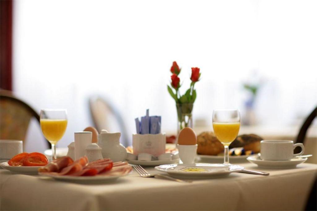 美因茨莫古缇娜酒店的一张桌子,上面放着食物和两杯橙汁