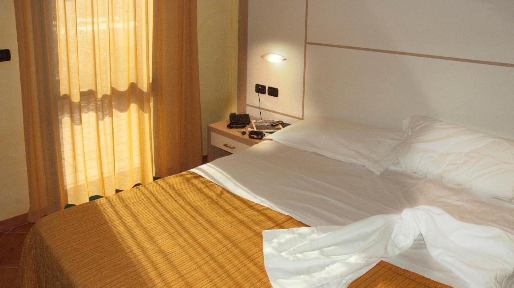 切萨雷奥港Baiamalva Resort Spa的窗户客房内的一张白色床