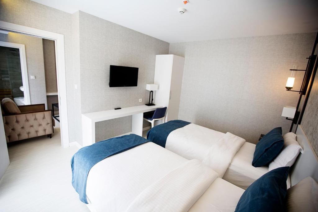 特拉布宗Gardenya Suite Hotel的酒店客房设有两张床和电视。