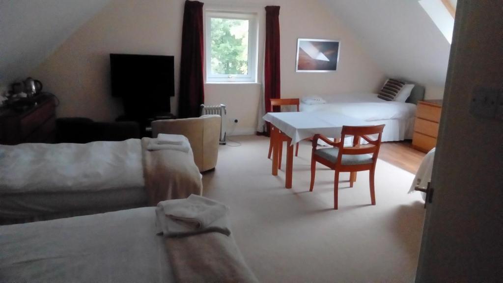 塔伯特Bluebell Cottage的客厅配有床和桌椅