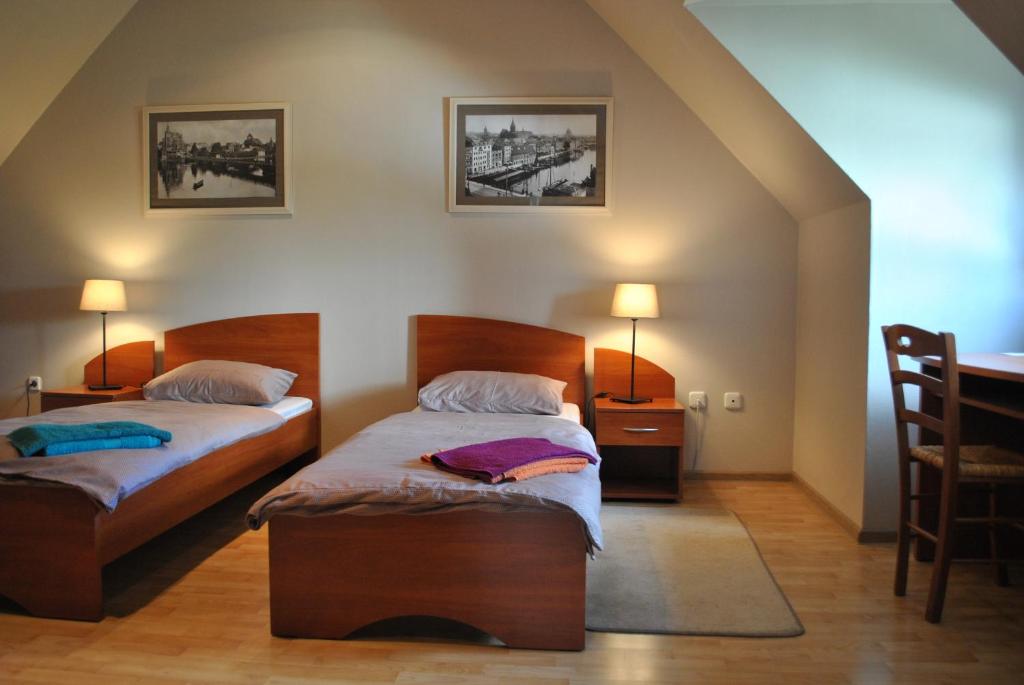 加里宁格勒House Na Kashtanovoj的一间卧室配有两张床和一张桌子及椅子