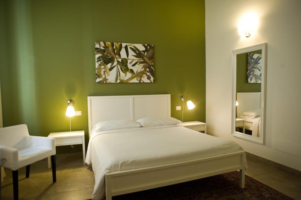 特拉尼B&B Suite Paciotti的一间卧室配有床、两张桌子和镜子
