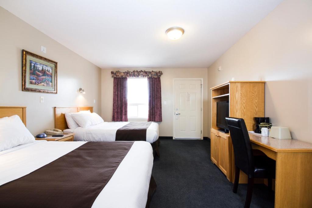 Drayton ValleyWest Country Inn的酒店客房配有两张床和一张书桌