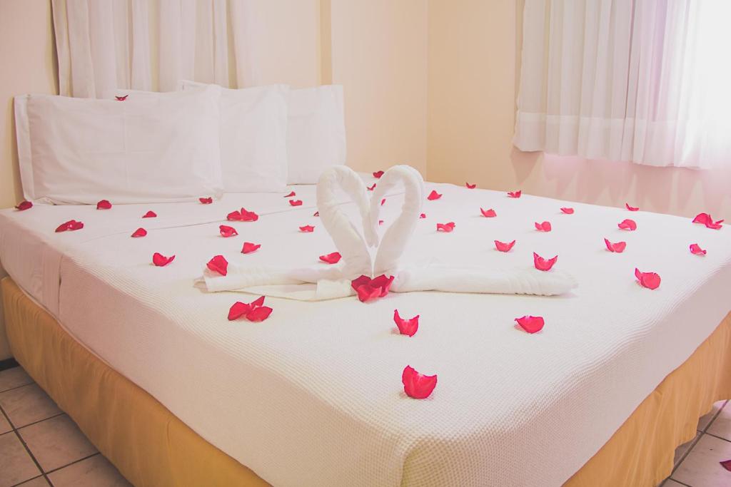 福塔莱萨JOH Blue Ocean Flat Hotel的一张红色玫瑰床,上面有白色的床单