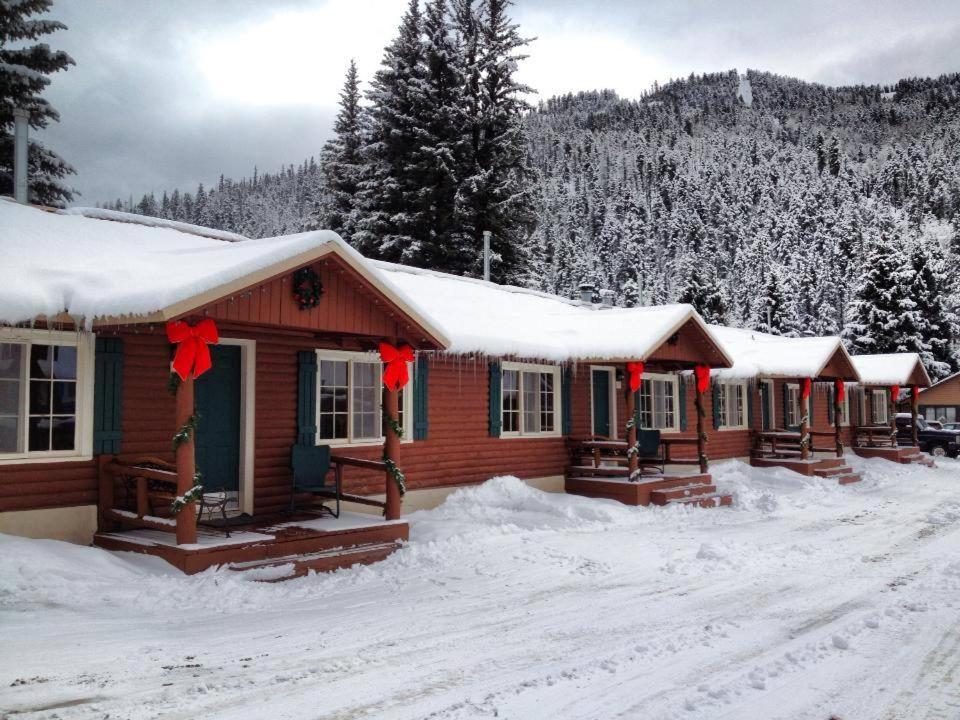 红河Three Bears Lodge的雪中带红色弓的度假小屋