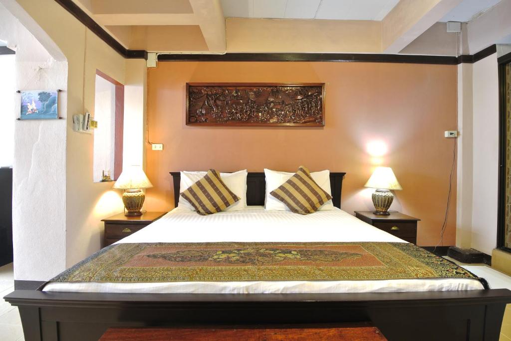 清迈皮萨马恩酒店的一间卧室配有一张大床和两盏灯