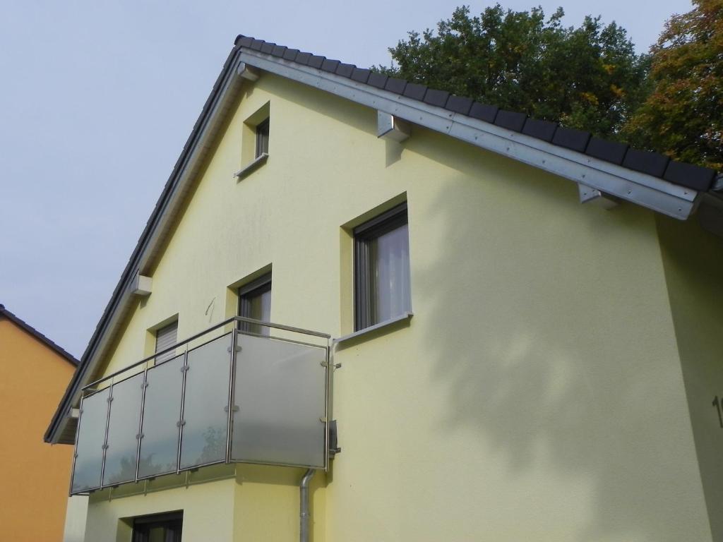 上阿斯巴赫1-Zimmer-Wohnung Nähe Playmobil Funpark的黄色的建筑,旁边设有阳台