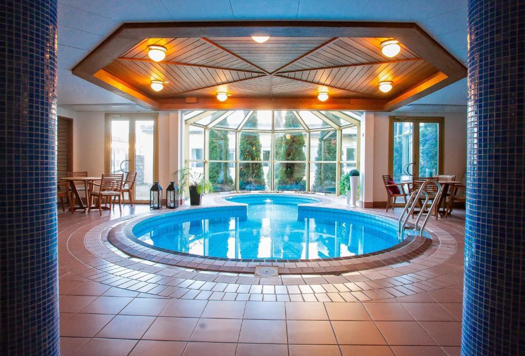 桑德维肯Clarion Collection Hotel Smedjan的酒店大堂的大型游泳池配有桌椅
