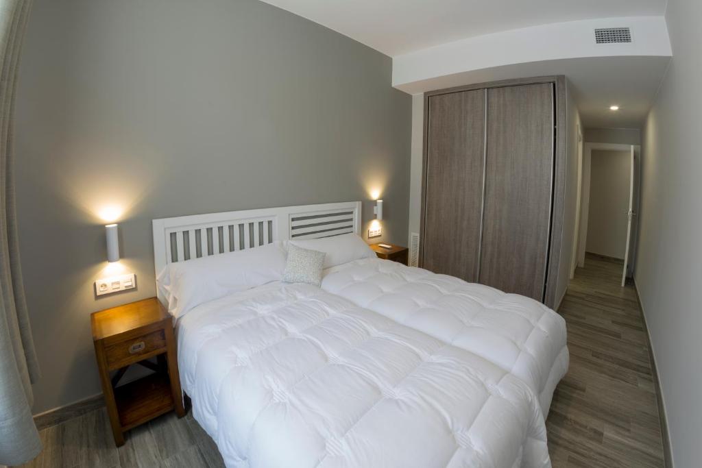 阿耶韦Hotel Asador O Callejón De Belchite的卧室内的一张大白色床,配有两盏灯