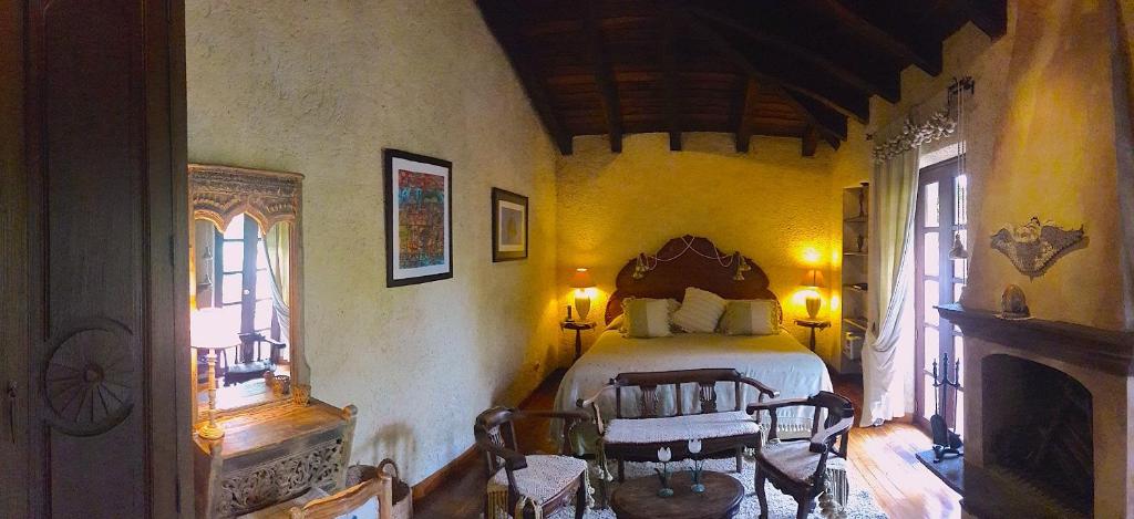 危地马拉安地瓜Cissus Hotel Boutique的一间卧室,卧室内配有一张床和椅子