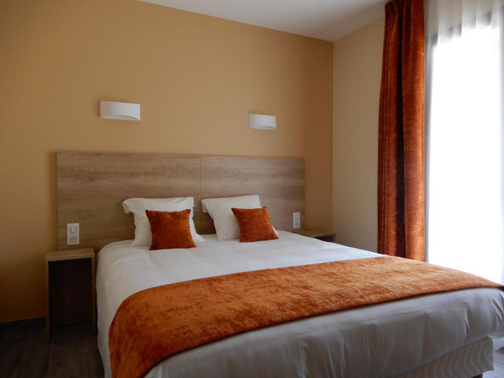 Châtillon-de-MichailleHotel Marinet的卧室配有带橙色枕头的大型白色床