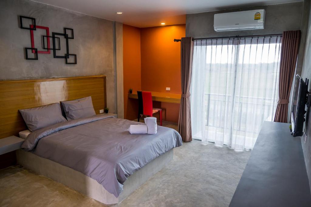 洛坤府B3酒店的一间卧室配有一张床、一张书桌和一个窗户。