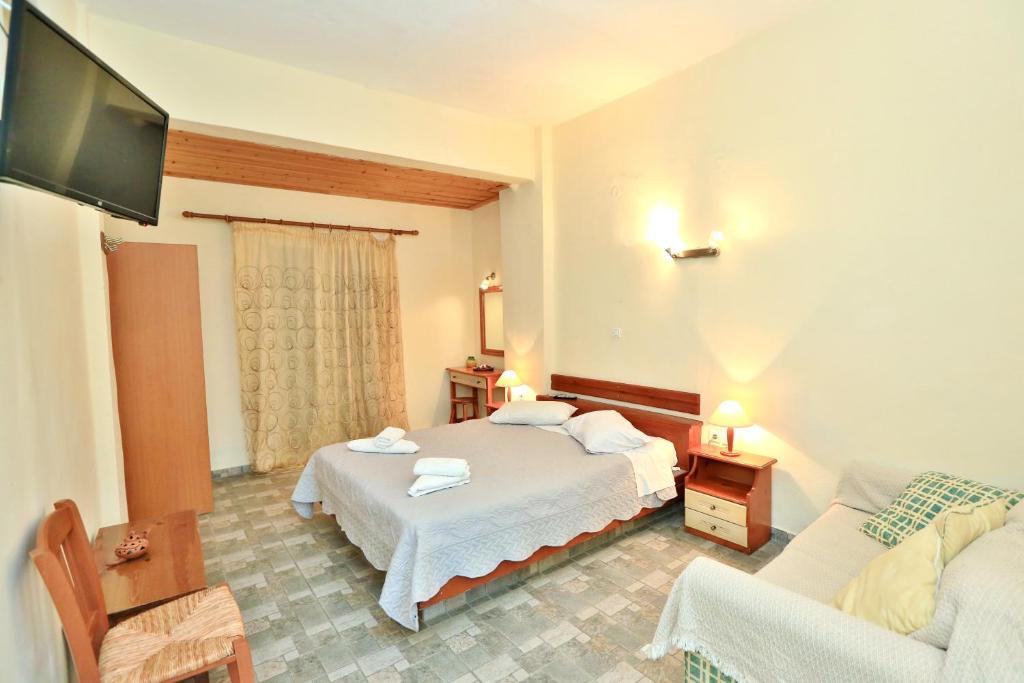 普拉提伊亚洛斯西弗诺斯基克拉泽斯海滩公寓式酒店的一间卧室配有一张床、一张沙发和一台电视。