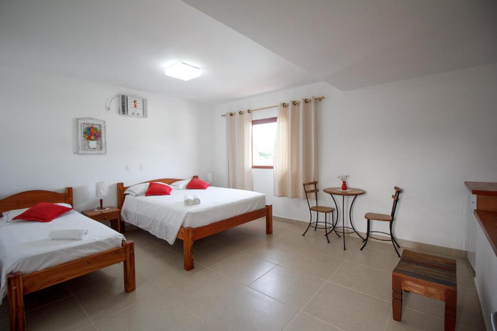 伯迪亚哥Pousada Acqua Azul的一间卧室配有两张床和一张桌子及椅子