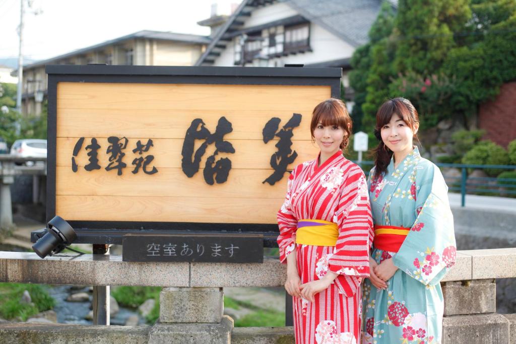 松江市南花粋苑旅馆的两个和服女郎站在一个标志前