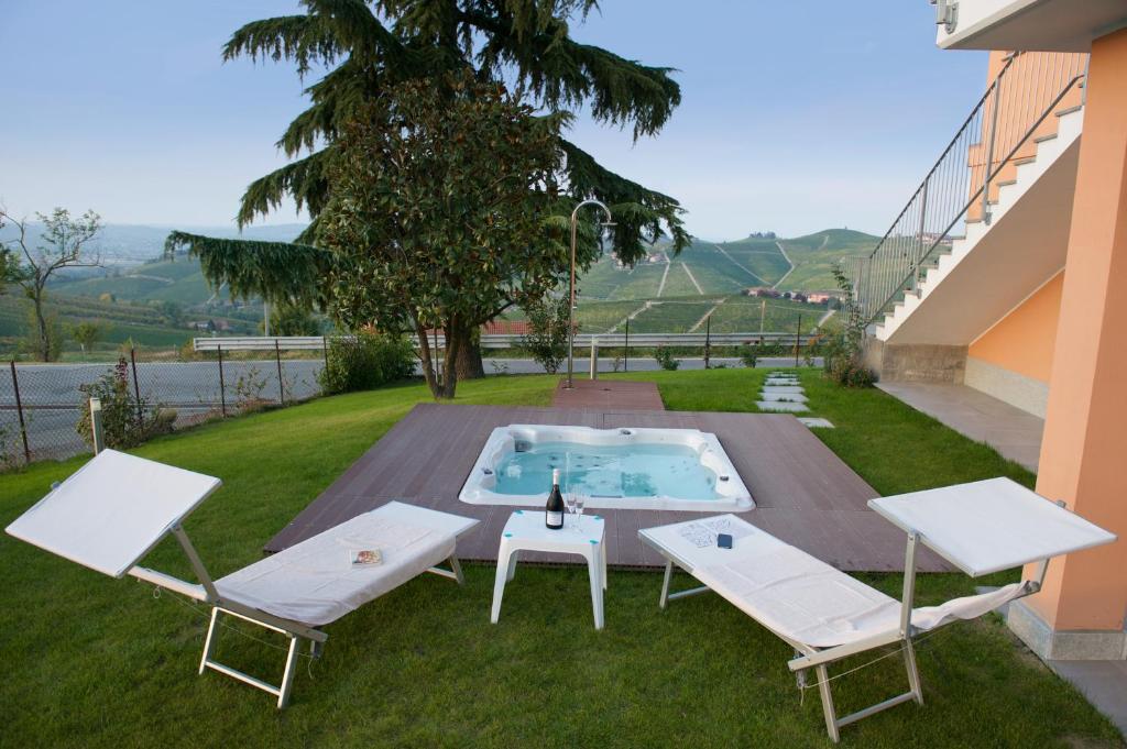 巴巴莱斯科Bella Vista Barbaresco的后院设有游泳池、2把椅子和1张桌子