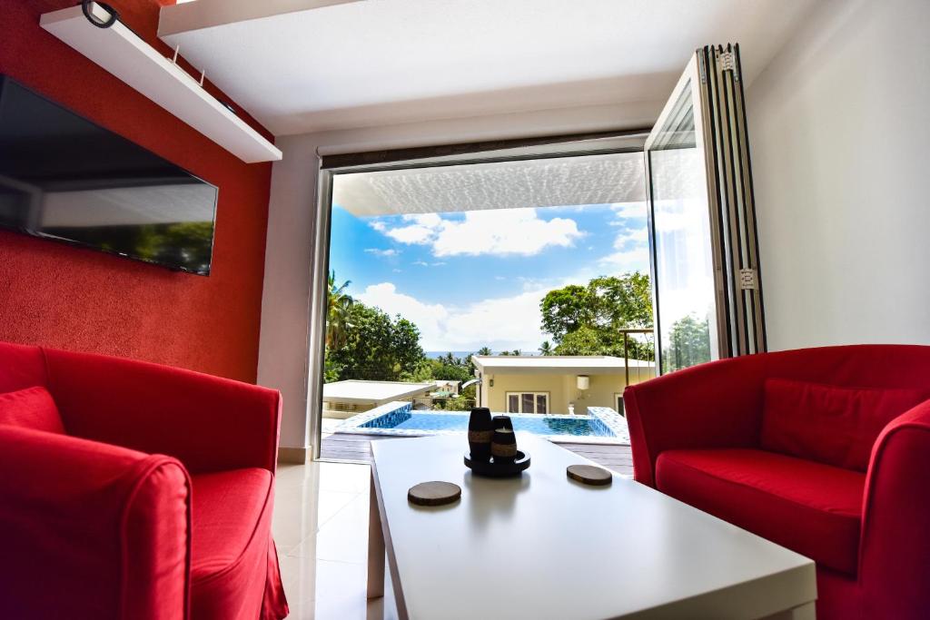 马埃岛穆林卡恩别墅的客厅配有红色椅子和白色桌子