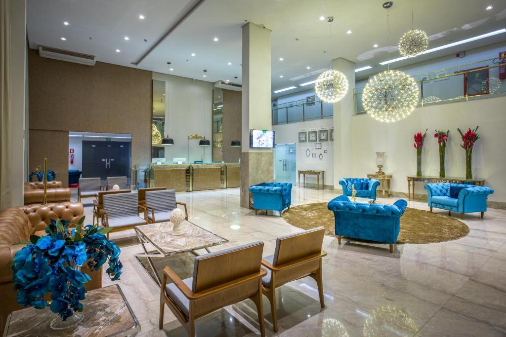 帕尔马斯CEU PALMAS Hotel的大楼内带蓝色沙发和椅子的大堂