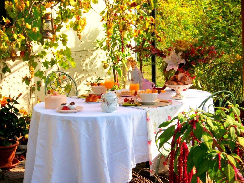 比斯卡罗斯Chambres "Au Jardin"的一张桌子,上面有白色的桌布,上面有食物