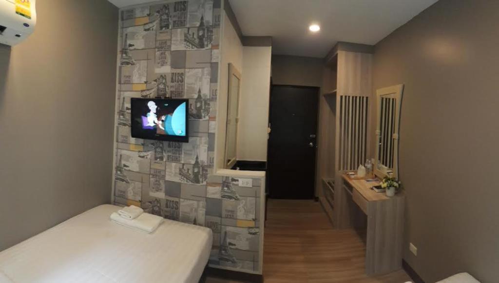 曼谷YWCA Hotel Bangkok的一间设有床铺和墙上电视的房间