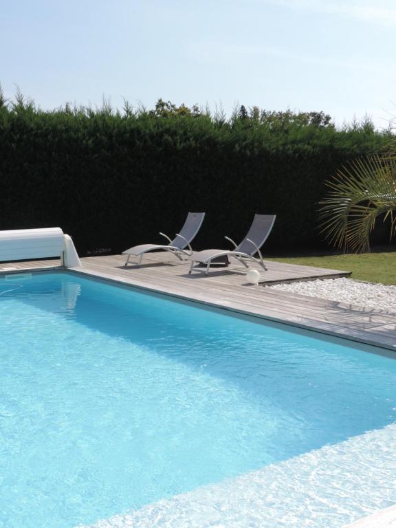 萨莱Maison d'Amis的游泳池旁设有2把躺椅