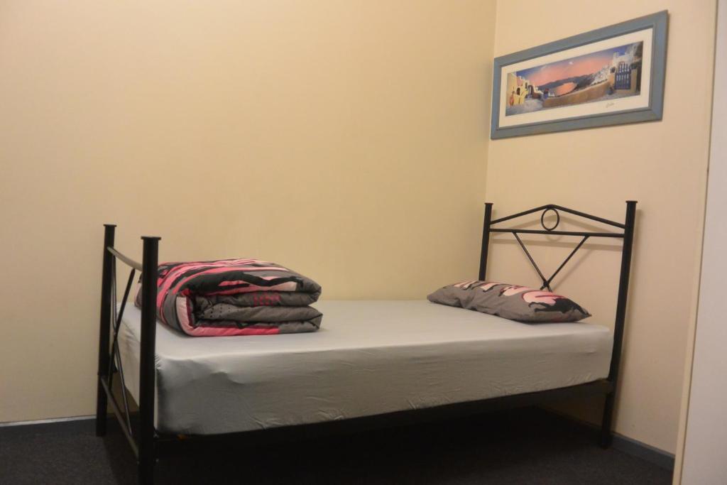墨尔本伊丽莎白旅舍的一张小床,上面有两个枕头