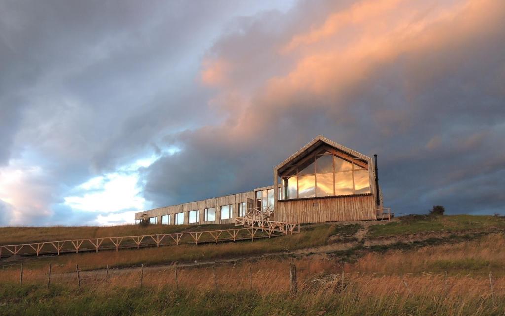 纳塔列斯港Hotel Simple Patagonia的云天山顶上的建筑