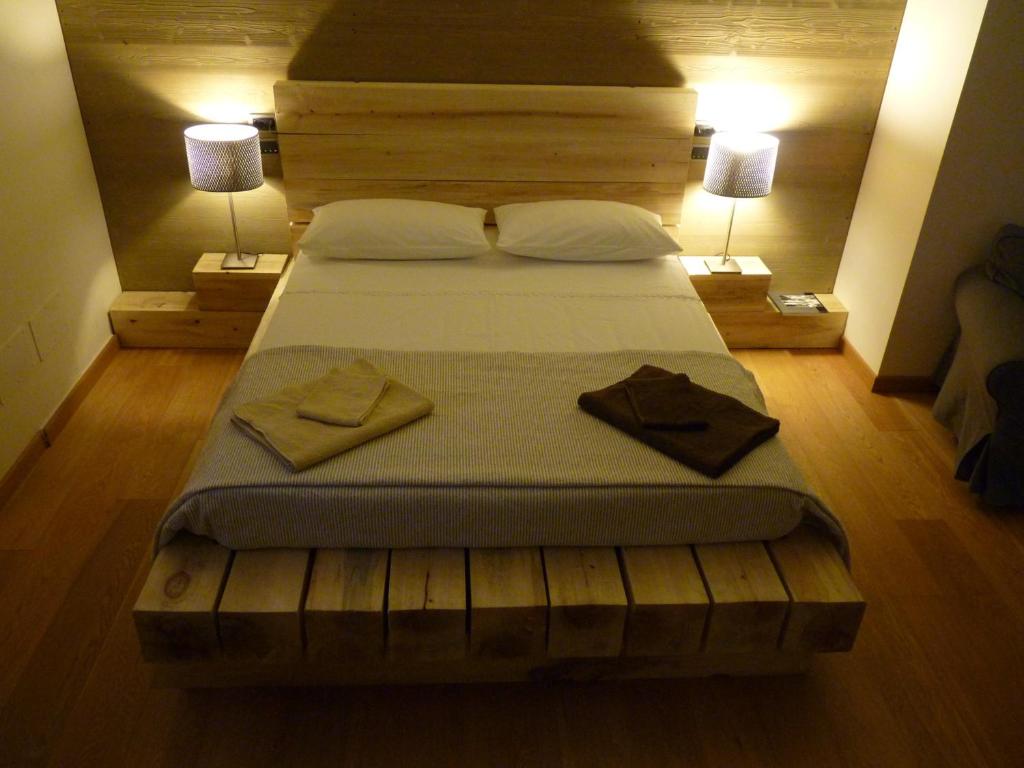 蒙多维Ca'Luna的卧室内的一张大床,配有两盏灯