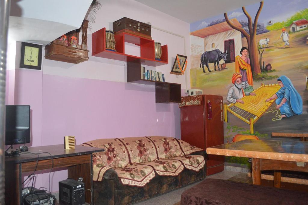 瓦拉纳西阿祖尔旅馆的客厅配有沙发和墙上的绘画