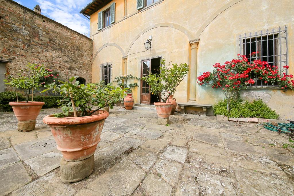 佛罗伦萨Villa Le Pergole- Firenze的建筑前的盆栽植物群