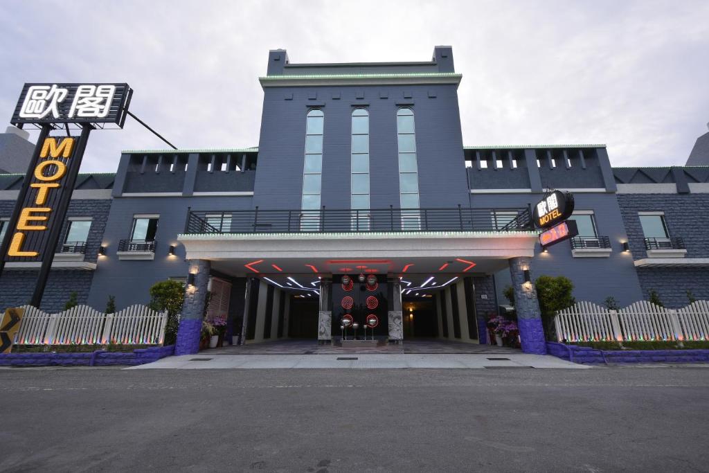 Jiuru欧阁汽车旅馆 - 屏东馆的蓝色的建筑,前面有标志