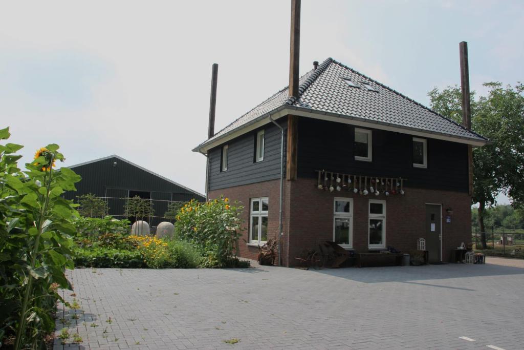 VolkelBed and Breakfast De Volkelse Hooiberg的一座黑屋顶和庭院的房子