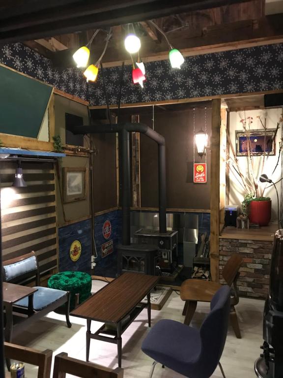 札幌Shabby House 的配有桌椅和燃木炉的房间