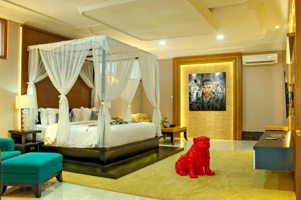 日惹雨树精品别墅及画廊旅馆的一间卧室配有一张带天蓬的白色床