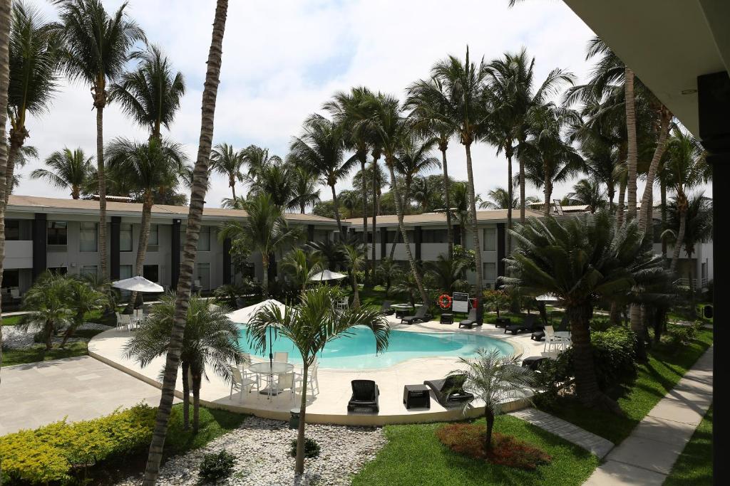 皮乌拉皮乌拉安迪纳优质酒店的享有带游泳池和棕榈树的度假村的景致