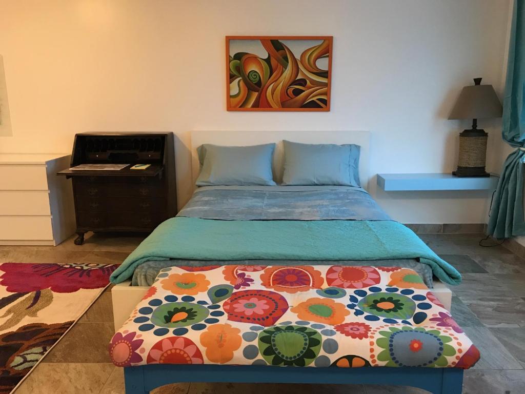 科迪亚克Aquamarine Suites的一间卧室配有一张带桌子和绘画的床