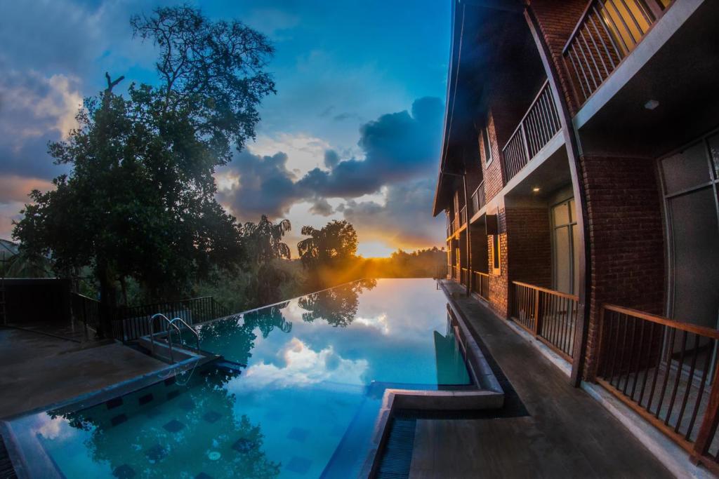 米瑞莎萨默塞特米日萨酒店的日落时分在游泳池中反射天空