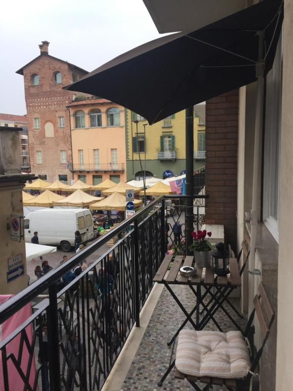 阿尔巴Lilly Rose Apartment的阳台配有桌子和雨伞。