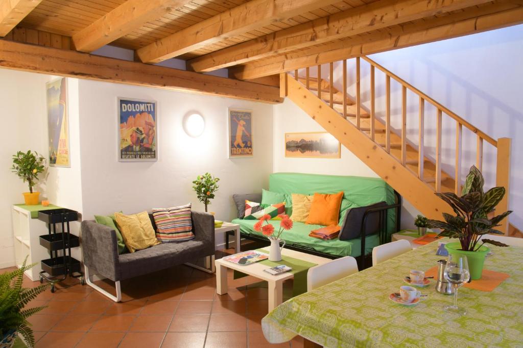 加尔达湖滨Casa al Pozzo的客厅设有绿色沙发和楼梯。
