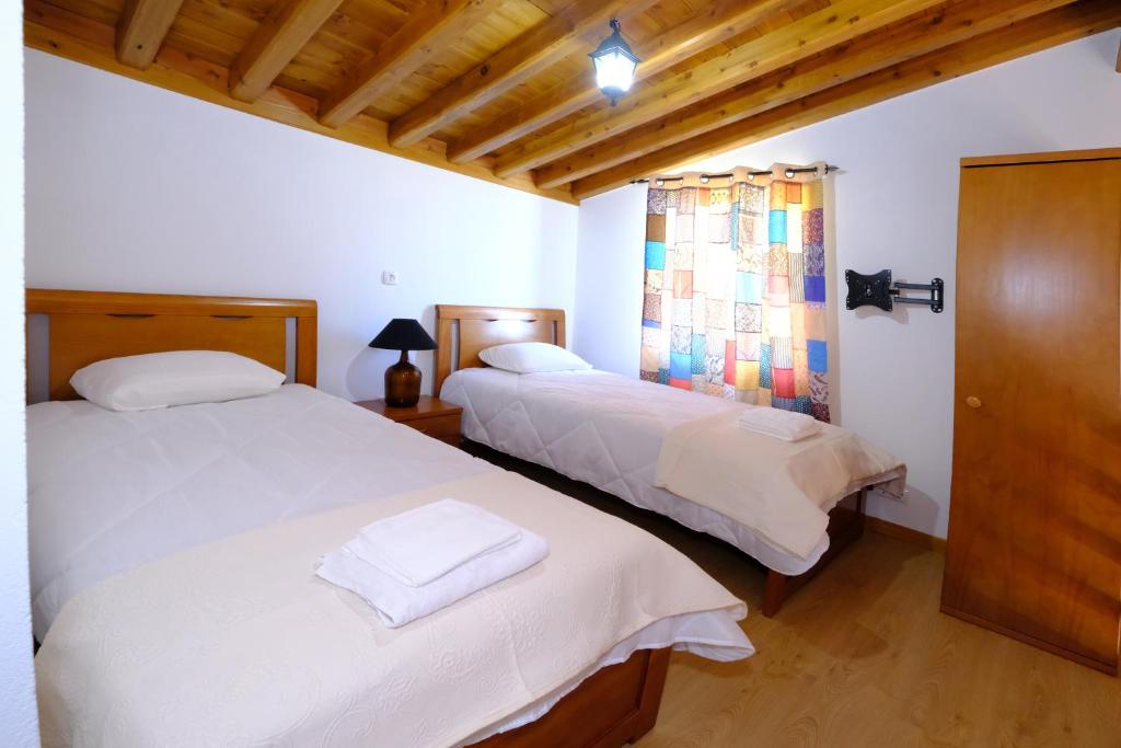 Alto do SulQuinta do Fragoso的一间卧室设有两张床和窗户。