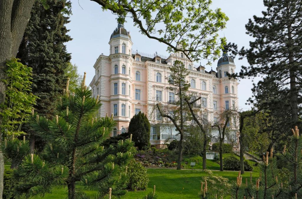 卡罗维发利布里斯托宫酒店的前景中树木的建筑物的图像