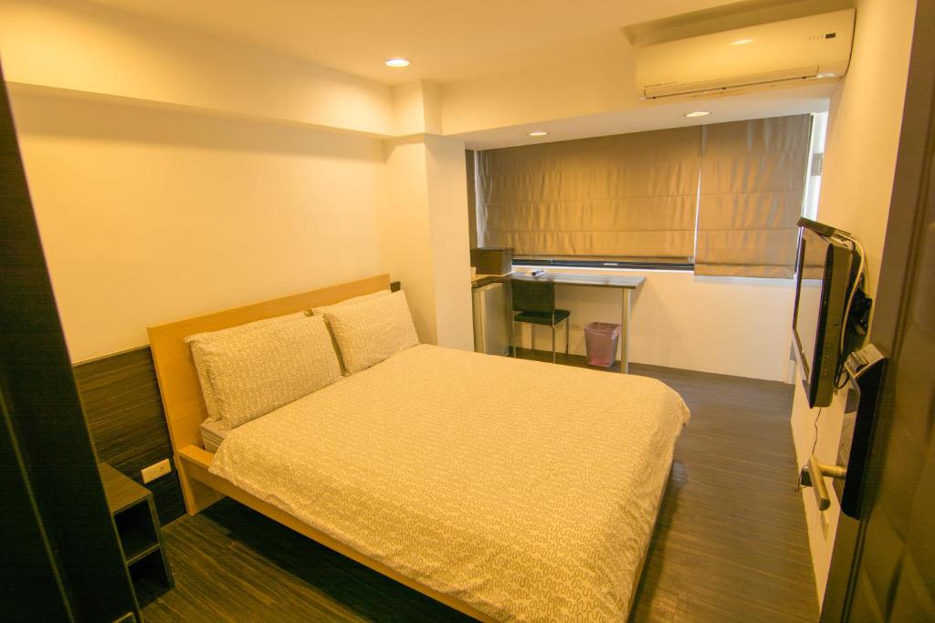 台北忠孝敦化民宿的小房间设有床和厨房