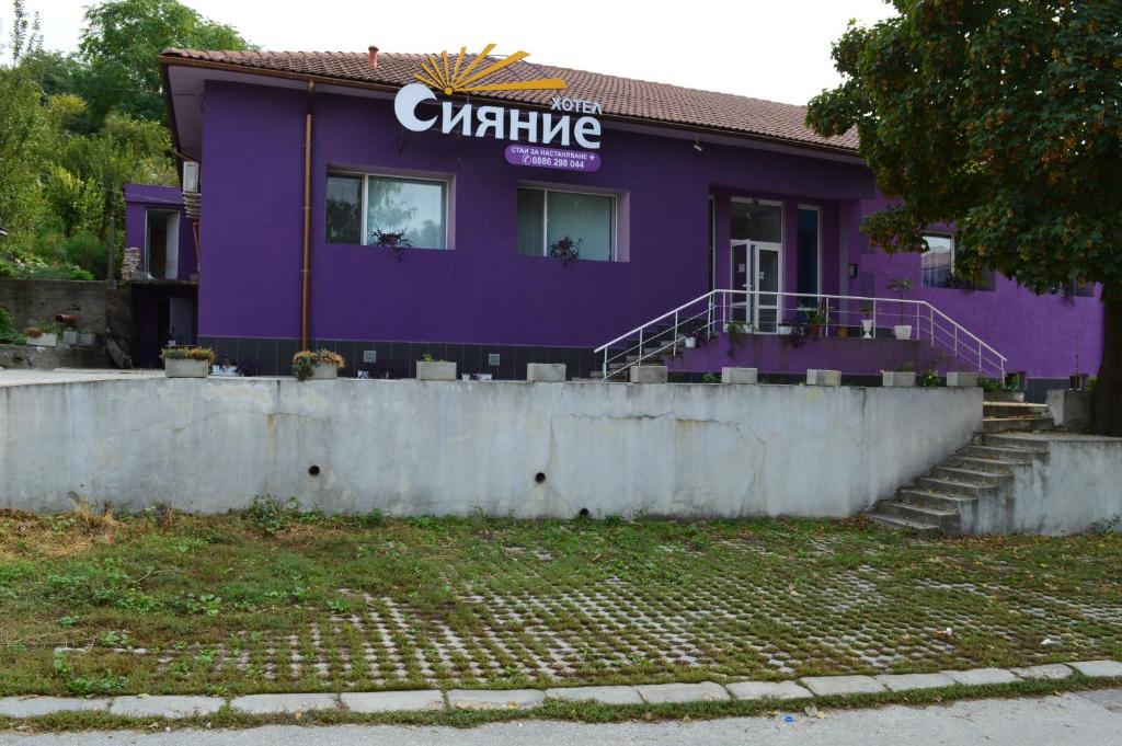 TutrakanHotel Sianie的紫色的建筑,上面有标志